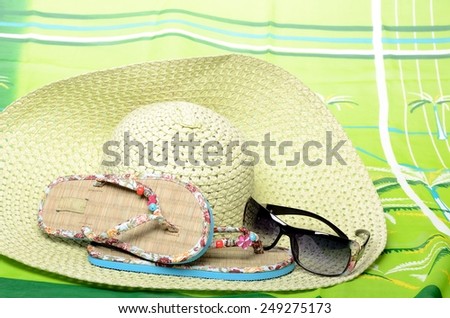 Beachfront set for summer vacation sandals, sunglasses, hat and pareo in still life