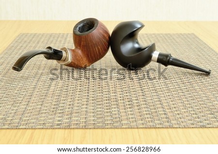 Still life of two smoking pipes for tobacco, lying on the table.