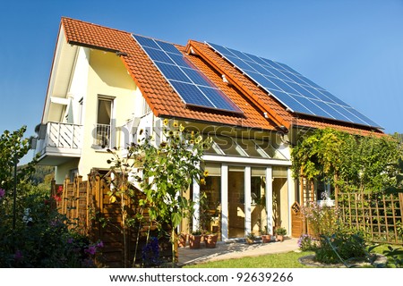 House with garden and solar panels on the roof