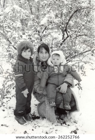 RUSSIA - CIRCA 1975: An antique Black & White photo of Two kids with mother  in a cold winter day.