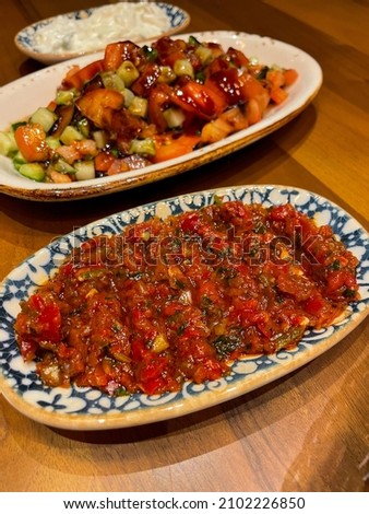 Traditional turkish spicy dip acili Ezme with red paprika pepper, tomatoes, onion and spices in small decorative plate in turkish restaurant Stok fotoğraf © 