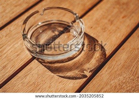 Similar – Image, Stock Photo Round glass ashtray with butts of cigarettes and colorful autumn leaves on a rustic wooden table with grain in autumn in the alleys of the old town of Detmold on the Teutoburg Forest in East Westphalia Lippe