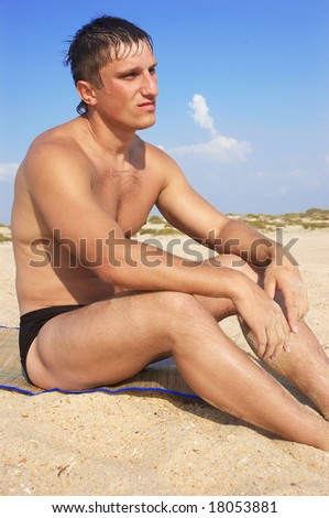 The man sits on sand in loneliness