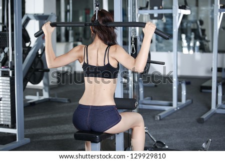 Woman at the gym doing exercises to strengthen the muscles of the back