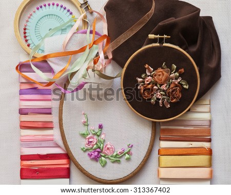 Homemade crafts. Process embroidery satin ribbons. Accessories for embroidery: needle, ribbon, canvas, tambour