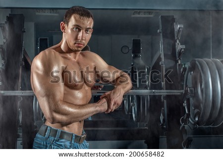 Bodybuilder man leaned wearily on the machine.