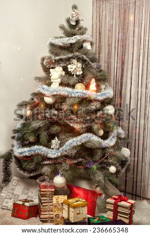 Decorated Christmas tree with gifts and balloons lights glitter.