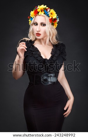 Woman with a wreath on her head in a black dress with large breasts and a slim waist.