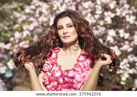 Girl brunette with long silky hair. The girl wearing pink floral dress.