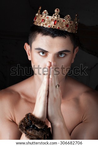 Guy put his hands and prays. On his head the king\'s crown.