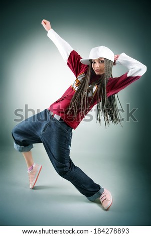 Portrait of dancing girl with dreadlocks in cap. Music and dance concept