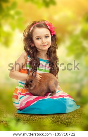 Happy little girl with rabbit. Greeting card. Happiness concept.