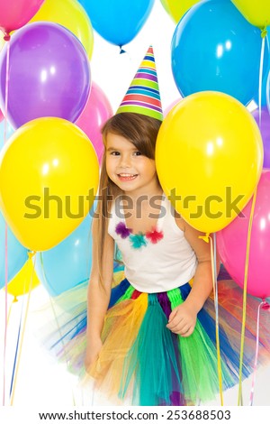 Happy little kid girl  with colorful balloons on birthday party. Holidays, birthday concept.