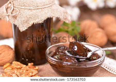 Jam-jar of walnuts on a wooden background