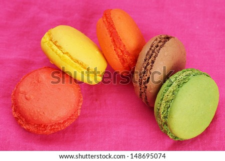 Group of colorful macaroons on bright pink cloth