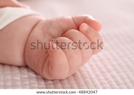 Baby Infant Hand on Pink Bed Sheet Linen