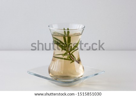 Rosemary tea in Armudu glass with branch of rosemary in it on the table on white background Photo stock © 