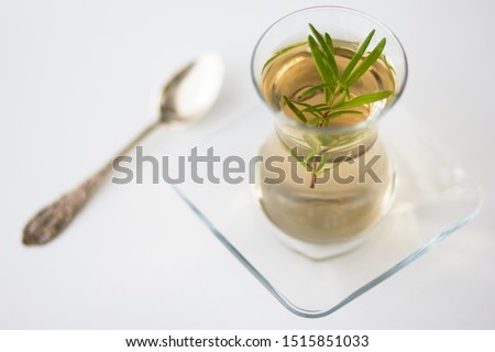 Rosemary tea in Armudu glass with branch of rosemary in it and spoon on the table on the white background Photo stock © 