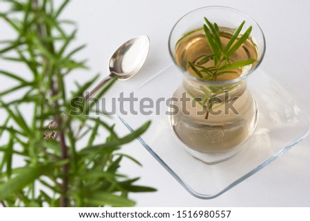 Rosemary tea in Armudu glass with branch of rosemary in it and spoon on the white table as background Photo stock © 