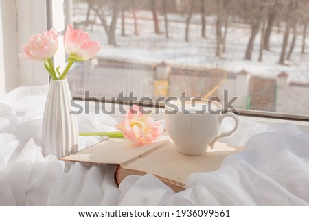 still life a vase with tulips, a cup of coffee and an old book on the window Stockfoto © 