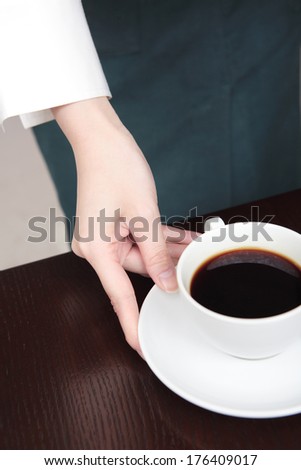 Japanese waitress holding cut of coffee