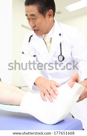 Doctor putting bandage the foot of the patient