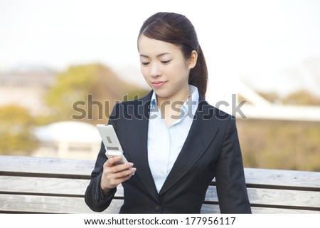 Japanese businesswoman who want to check the mail by mobile phone