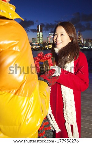 Japanese woman passing the Christmas gift to men