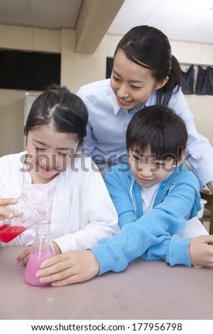 Primary boy, Japanese girl and the female teacher who experiments on the science