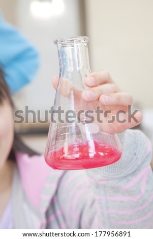 Hand of elementary girls with a flask