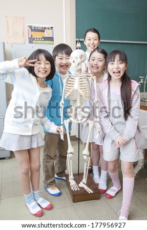 Female teachers and elementary children playing in the skeleton model