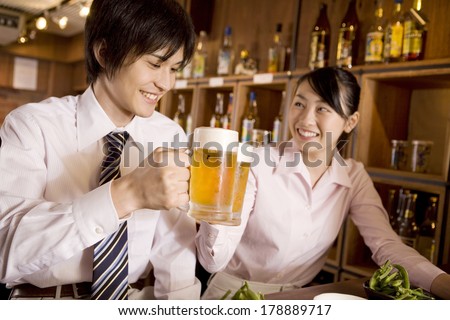 Businessman and Japanese businesswoman toasting with a beer