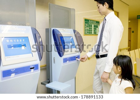 Japanese man and girls inserting the consultation card into the card writer