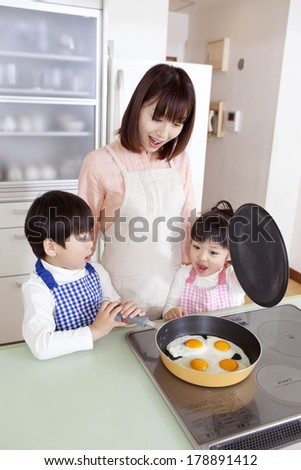 Japanese boy and Japanese woman cooking with eggs