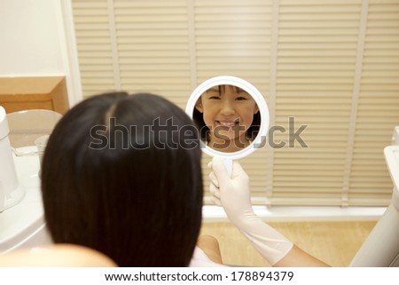 Japanese girl looking at herself in the mirror