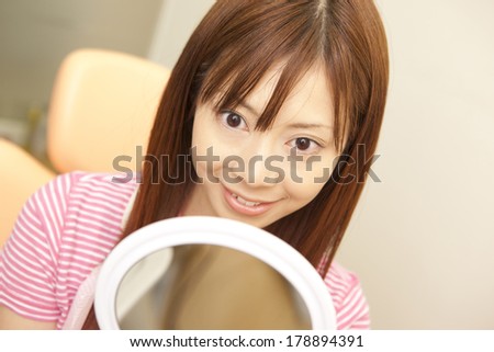 Japanese woman looking in the mirror after treatment