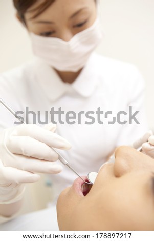 Japanese man being treated by dental hygienist