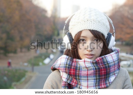 Japanese woman smiling while listening to music
