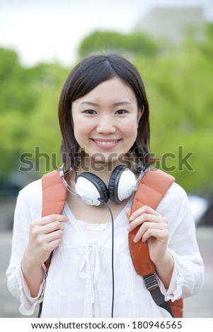 Japanese Students smiling with their headphones rested on their neck,