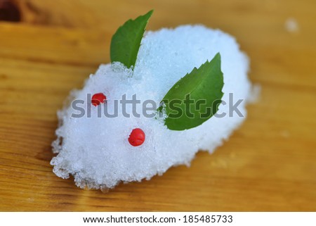 Rabbit made with snow, holly leaves, and berries