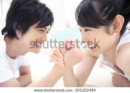 Couple doing arm wrestling in bed