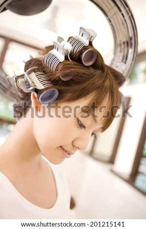 Woman getting a perm at hair salon