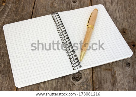 Notebook with a pen on the old wooden floor
