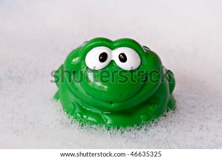 green funny frog in a bath foam