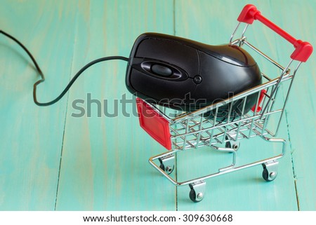Shopping cart with a computer mouse on blue background