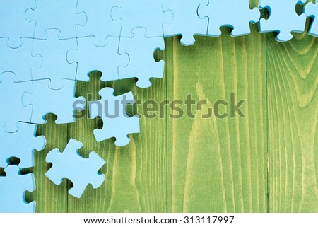 Puzzle on green wooden background.Team business concept