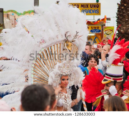 SANTA CRUZ, SPAIN - FEB 12: Parade participants in colorful costumes march through the streets in carvival parade on February 12, 2013 in Santa Cruz de Tenerife, Spain