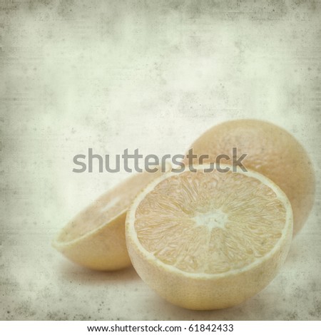 textured old paper background with cut orange fruit;