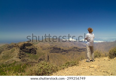 from the shadow of Roque Nublo - view west from the base of the Roque Nublo, tourist looking at the view