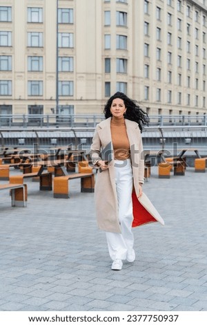 Similar – Image, Stock Photo Stylish businesswoman walking along street in city